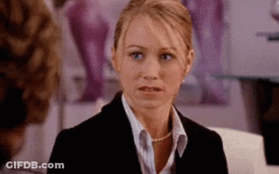 Woman In Suit And Pearl Necklace Sitting GIF