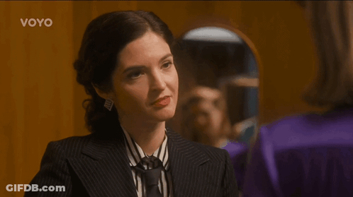 Woman In Suit And Tie Looking In Mirror Voyo GIF
