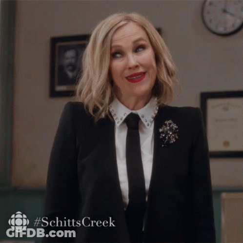 Woman In Suit And Tie Smiling With Schitts Creek GIF
