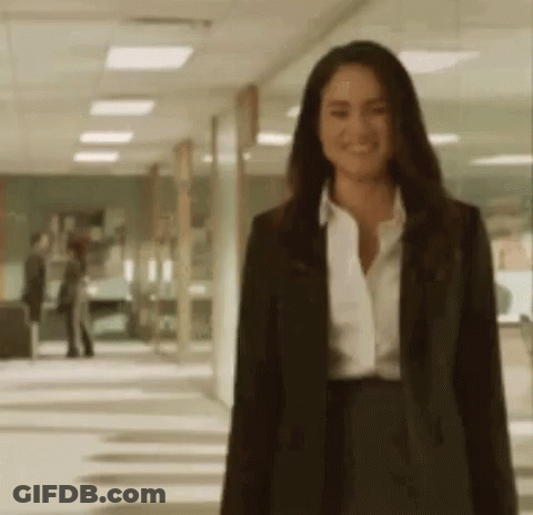 Woman In Suit And White Shirt Standing In Hallway GIF