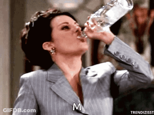 Woman In Suit Drinking Bottle GIF