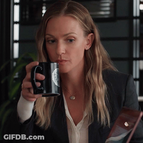 Woman In Suit Drinking From Black Mug With Circle GIF