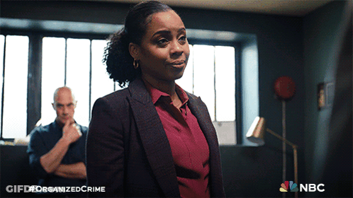 Woman In Suit Facing Man With Arms Crossed NBC Logo GIF