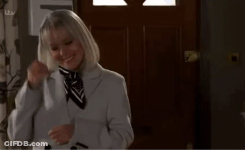 Woman In Suit Holding Phone To Neck GIF