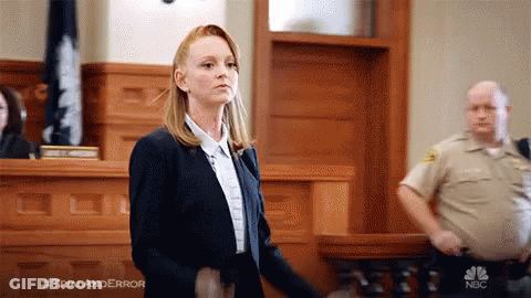 Woman In Suit In Courtroom With Police Officer GIF