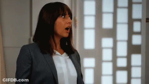 Woman In Suit Looking Surprised In Front Of Window GIF