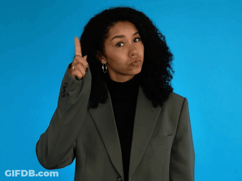 Woman In Suit Pointing Upward GIF