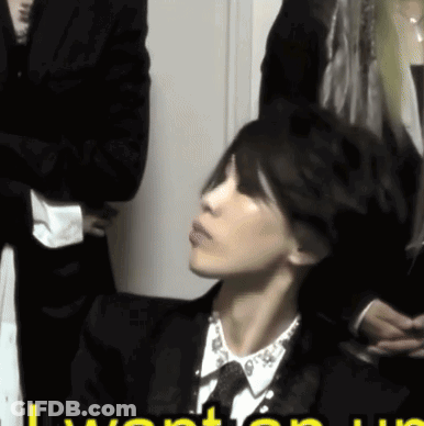 Woman In Suit Sitting In Front Of I Want You Sign GIF