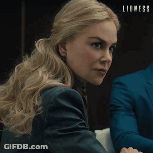 Woman In Suit Sitting Next To Man In Blue Suit Saying Lioness GIF