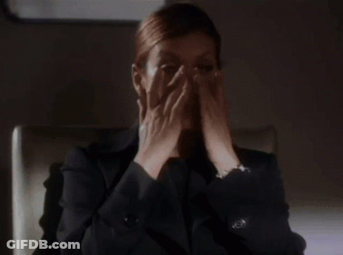 Woman In Suit Sitting With Hands Up GIF