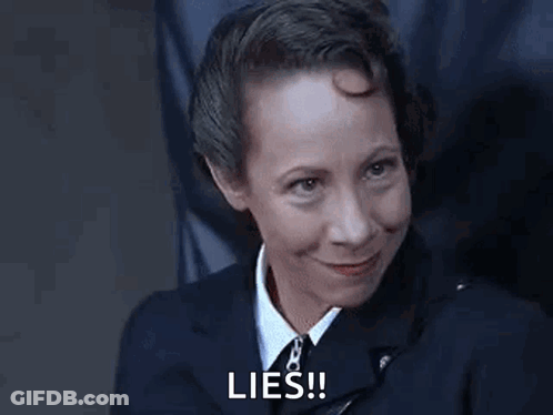 Woman In Suit Smiling Says Lies GIF