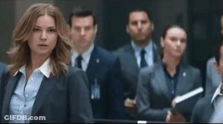 Woman In Suit Standing In Crowd GIF