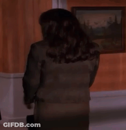 Woman In Suit Standing In Front Of Painting GIF
