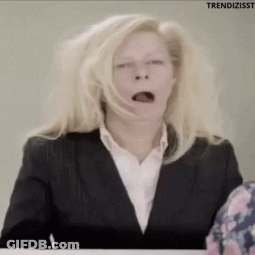 Woman In Suit Yawning At Desk GIF