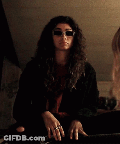 Woman In Sunglasses And Black Jacket Gesturing At Mirror GIF