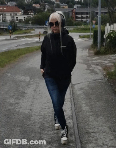 Woman In Sunglasses And Headphones Walking GIF