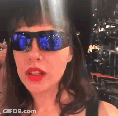 Woman In Sunglasses And Red Lipstick Looking At Camera GIF