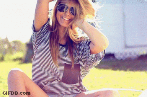 Woman In Sunglasses And Striped Shirt Smiling On Grass GIF