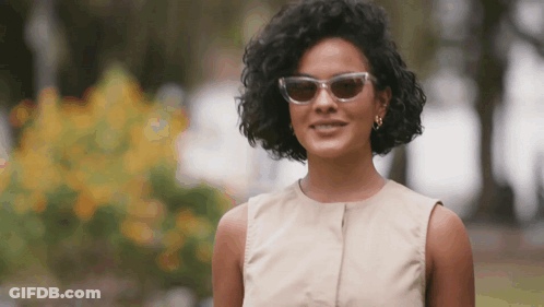 Woman In Sunglasses And Tan Dress Smiling GIF
