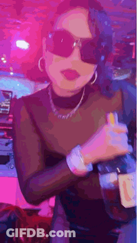 Woman In Sunglasses And Turtleneck Holding Alcohol GIF