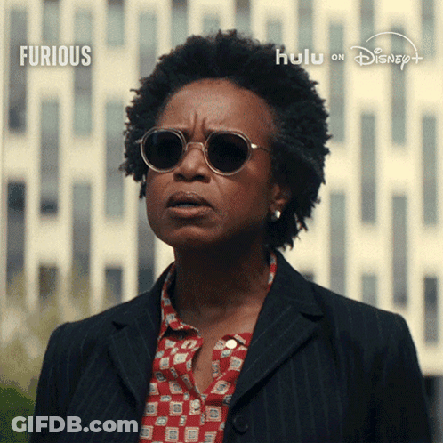 Woman In Sunglasses Before Furious Sign GIF
