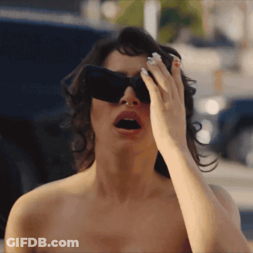 Woman In Sunglasses Covering Eyes With Hand GIF