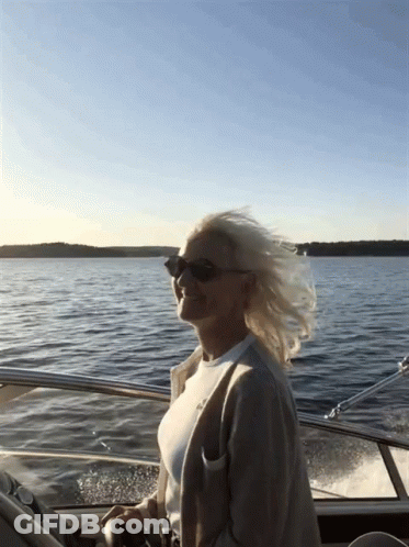 Woman In Sunglasses Driving Boat GIF