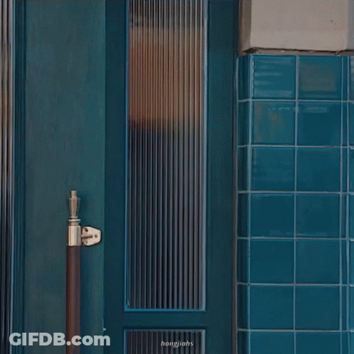 Woman In Sunglasses In Front Of Blue Door GIF