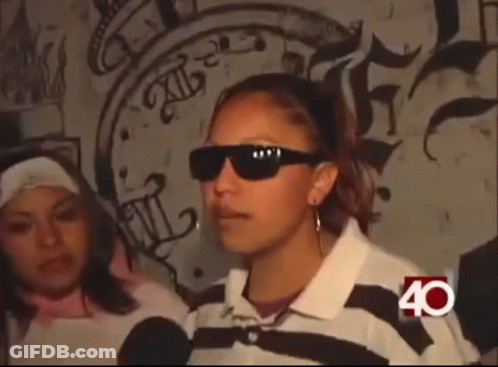 Woman In Sunglasses In Front Of Graffiti Wall GIF