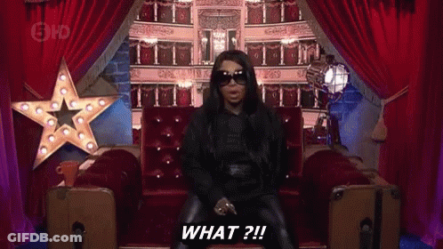 Woman In Sunglasses Sitting On Couch Saying What GIF