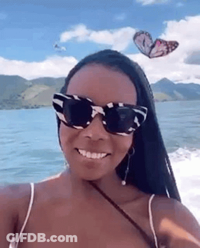 Woman In Sunglasses Taking Selfie On Boat With Butterflies GIF