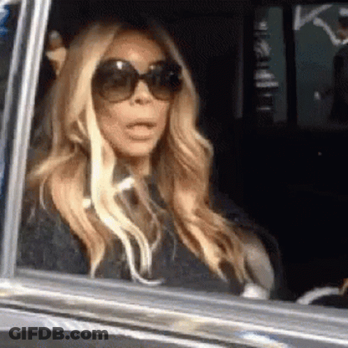 Woman In Sunglasses With Mouth Open In Car GIF