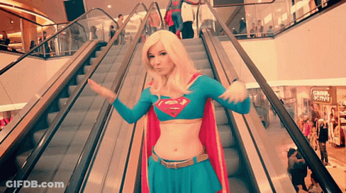 Woman In Supergirl Costume On Escalator GIF