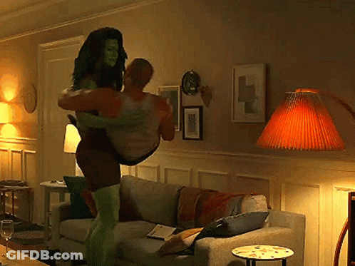 Woman In Superhero Costume Carrying Man GIF