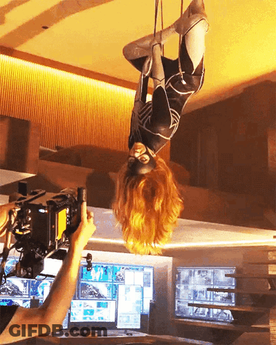 Woman In Superhero Costume Hanging Upside Down GIF