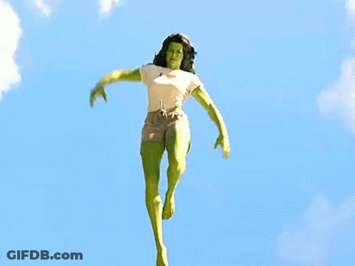 Woman In Superhero Costume Jumping With Arms Outstretched GIF