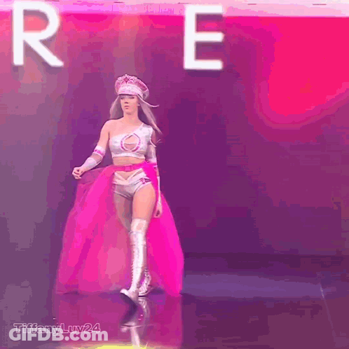 Woman In Superhero Costume Walking In Front Of Letter R GIF