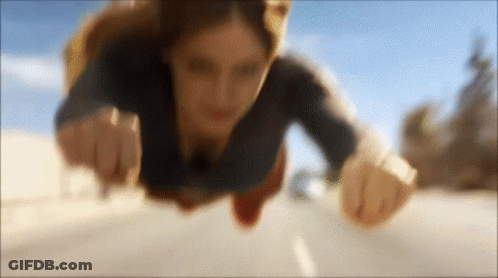 Woman In Superman Costume Flying Over Road GIF