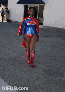 Woman In Superman Costume Walking Down Street GIF