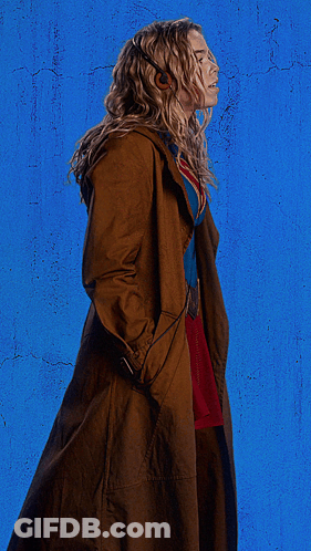Woman In Superman Costume With Headphones And Trench Coat GIF