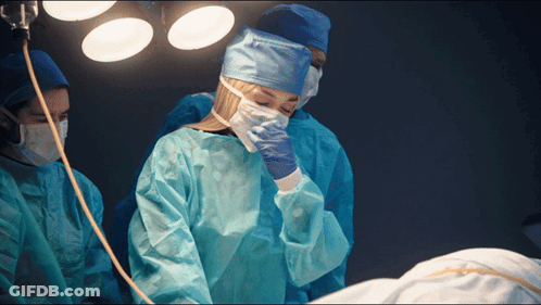 Woman In Surgical Gown Covering Face GIF