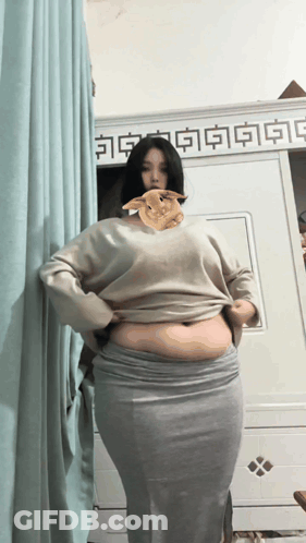 Woman In Sweater And Skirt With Rabbit On Chest GIF