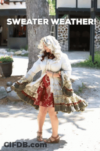 Woman In Sweater Weather Outfit Standing On Street GIF