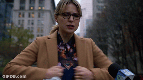 Woman In Tan Coat Speaking Into CBS Microphone GIF