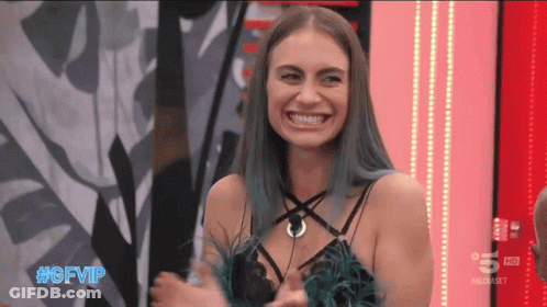 Woman In Tan Coat Speaking Into CBS Microphone GIF