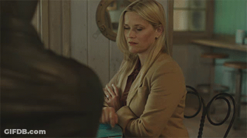 Woman In Tan Jacket Sitting At Table GIF