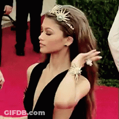 Woman In Tiara And Bracelets On Red Carpet GIF