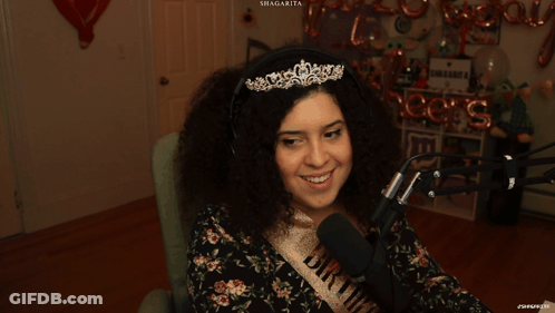 Woman In Tiara And Bride Sash Smiling At Microphone GIF