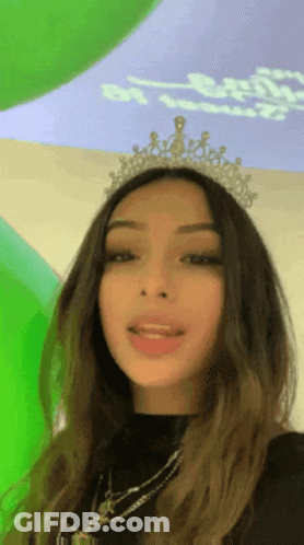 Woman In Tiara At Green Wall GIF