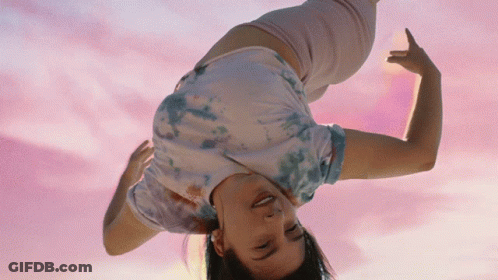 Woman In Tie Dye Shirt Doing Handstand GIF